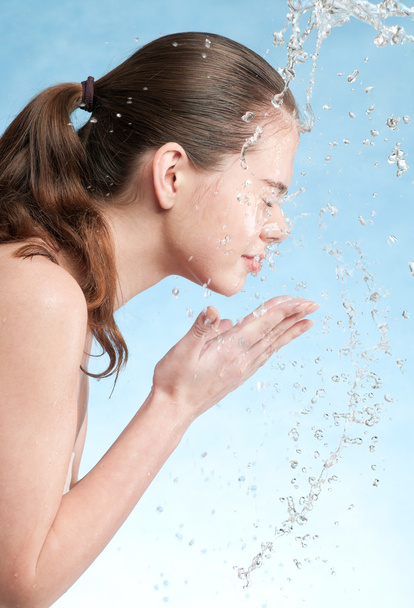 Portret van mooie emotionele vrouw gezicht wassen - Foto, afbeelding