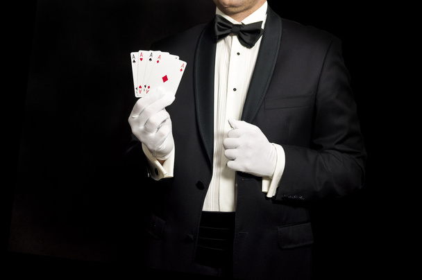 Elegant man in tuxedo holding 4 aces in hand - Foto, imagen