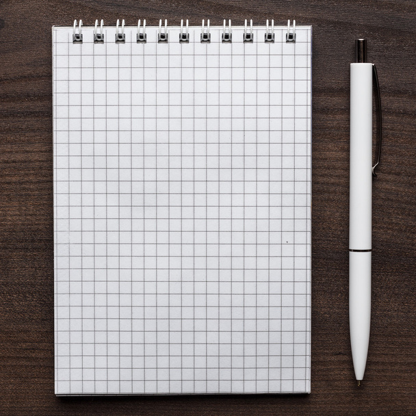 blank notebook and white pen - Foto, afbeelding