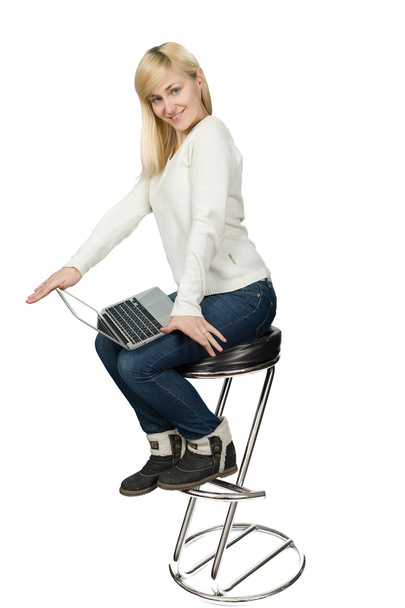 Бизнес-леди сидит на стульчике и работает на ноутбуке
 - Фото, изображение