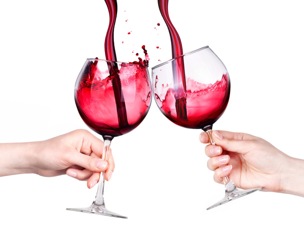 Glasses of red wine with splashes in hand isolated - Photo, image