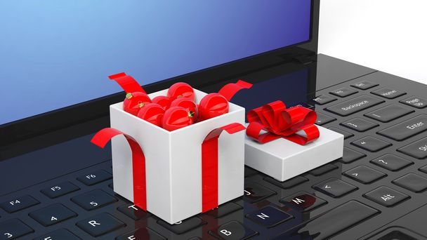Open gift box full of Christmas balls on laptop keyboard. - Zdjęcie, obraz