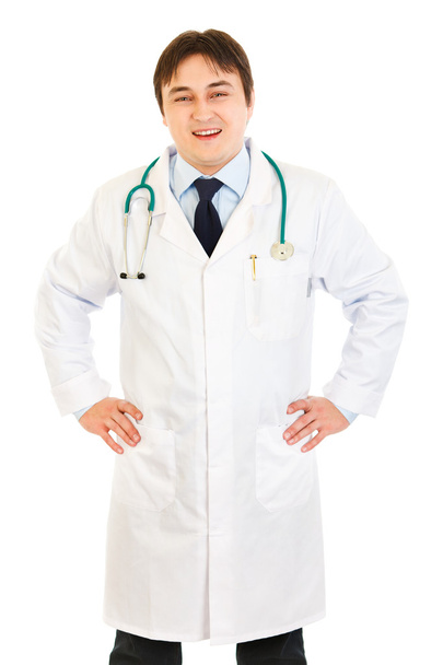Smiling medical doctor with stethoscope holding hands on hips - Foto, Bild