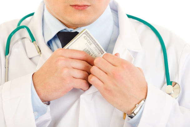 Medical doctor putting money in pocket. Close-up. - Valokuva, kuva