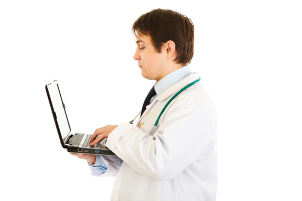 Serious medical doctor working on laptop - Fotó, kép