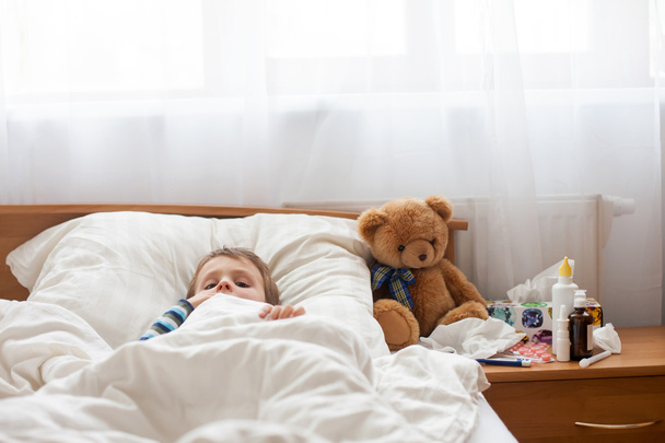 Sick child boy lying in bed with a fever, resting - Photo, Image