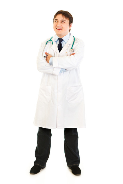 Full length portrait of smiling doctor with crossed arms on chest looking - Фото, изображение
