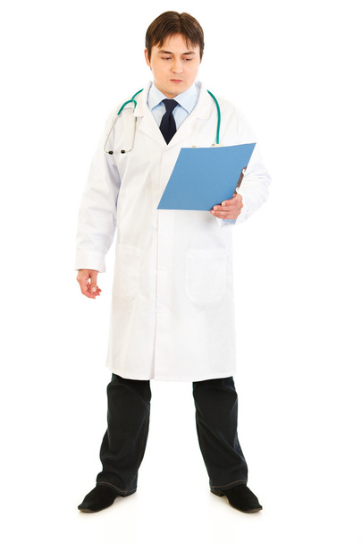 Serious medical doctor looking at patients chart - Foto, Imagem