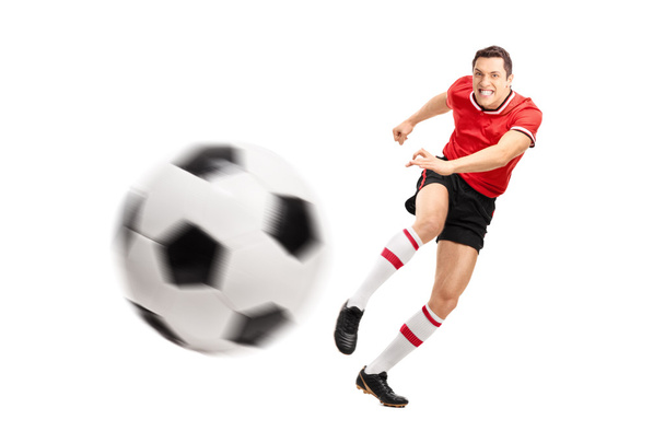 Young football player kicking a ball - Foto, afbeelding