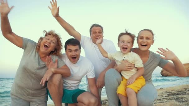 Μεγάλη ευτυχισμένη οικογένεια κουνώντας τα χέρια στην παραλία - Πλάνα, βίντεο