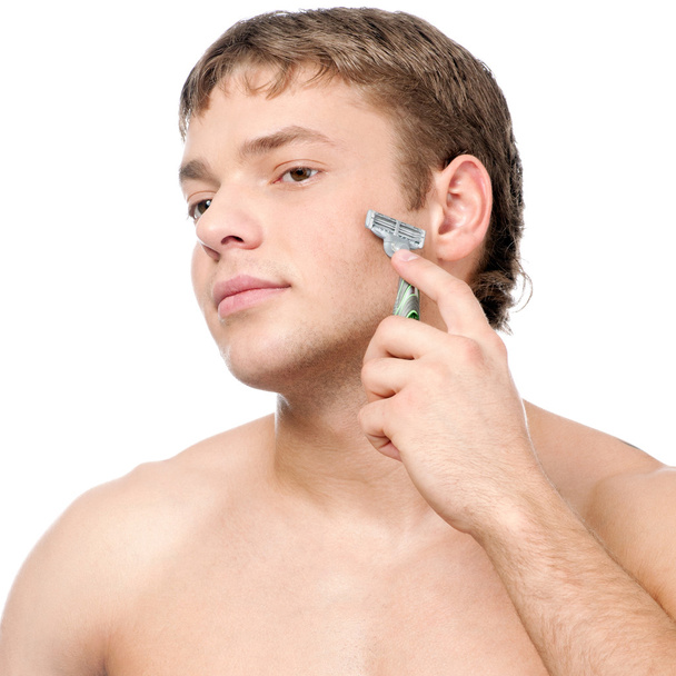 Portrait of a young handsome man shaving - Foto, afbeelding