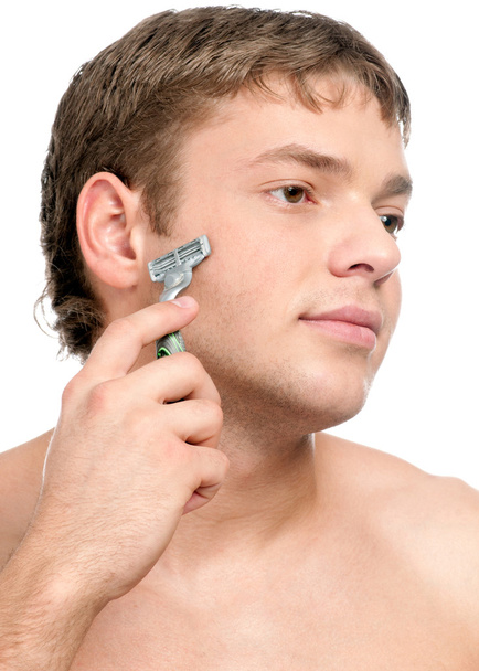 Portrait of a young handsome man shaving - 写真・画像
