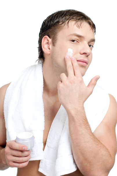 Man putting on cream lotion on face - 写真・画像