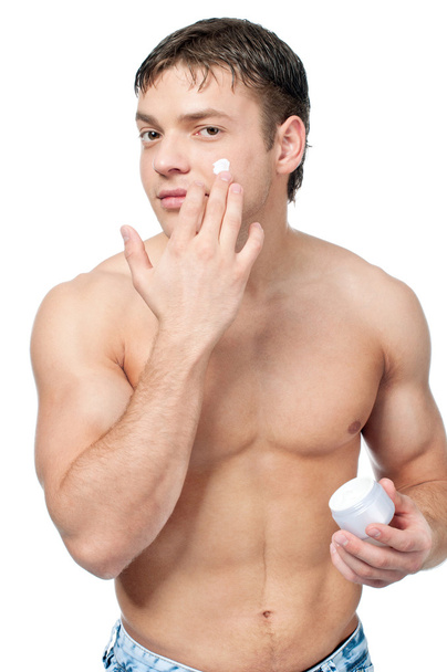 Man putting on cream lotion on face - 写真・画像