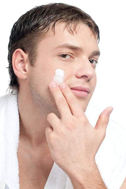 Man putting on cream lotion on face - Zdjęcie, obraz