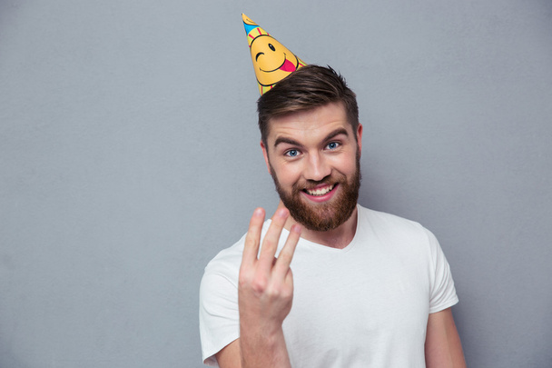Man with birthday hat showing three fingers - Fotó, kép