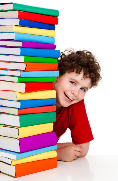 Boy behind pile of books isolated on white background - Foto, Bild