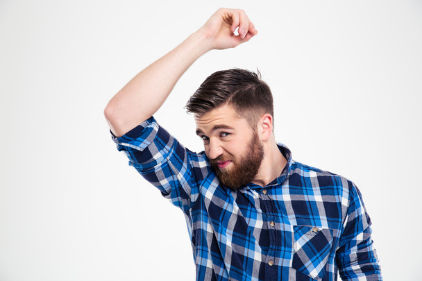 Portrait of a casual man smelling his armpit - Photo, Image