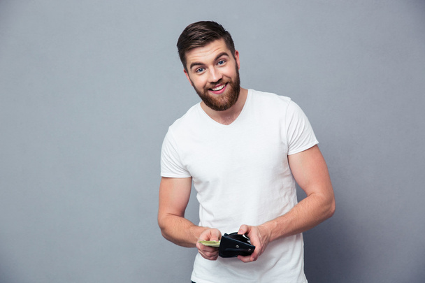 Portrait of a happy man holding wallet with money - Photo, Image
