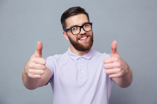 Casual man in glasses showing thumb up - 写真・画像