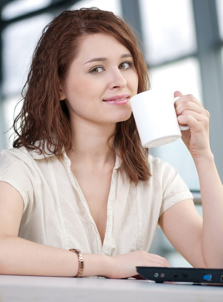 Business woman with a laptop and mug - Foto, afbeelding