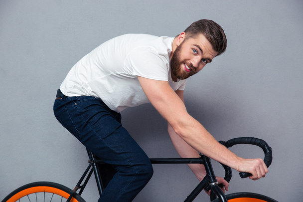 Portrait of a smiling man riding on bicycle - Foto, Bild