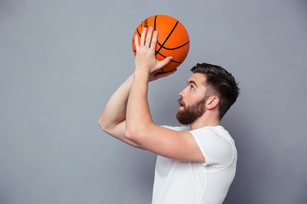 Young man reading to throw basket ball - Fotó, kép