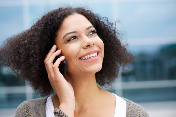 Lachende Afrikaanse Amerikaanse vrouw praten over cellphone - Foto, afbeelding