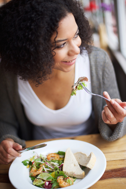 Sorridente donna afro-americana che mangia nel ristorante
 - Foto, immagini