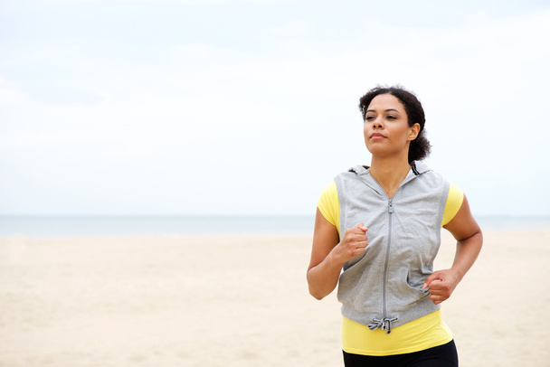 ビーチでジョギング若いアフリカ系アメリカ人女性 - 写真・画像