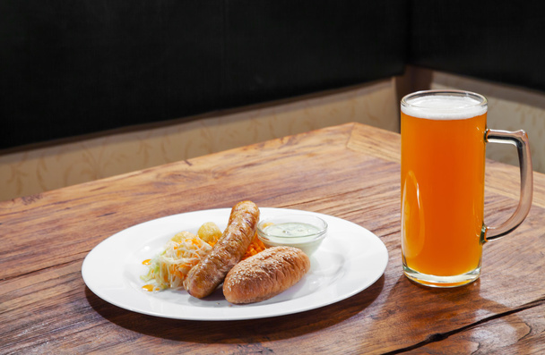 колбасы с овощами и кружка с пивом
 - Фото, изображение