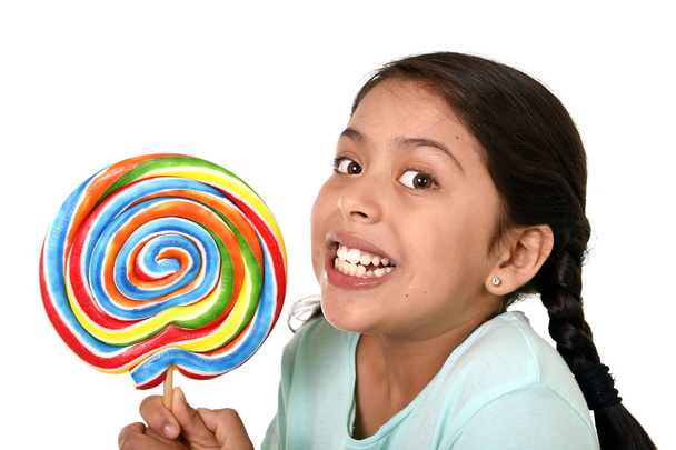 happy female child holding big lollipop candy in cheerful face expression in kid love for sweet concept - Foto, Bild