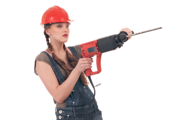 Young playful woman in jeans coverall holding perforator drill - Foto, Imagen