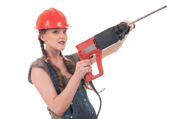 Young playful woman in jeans coverall holding perforator drill - Foto, Imagem
