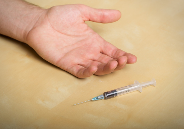 Hand addict and syringe with a drug - Фото, зображення