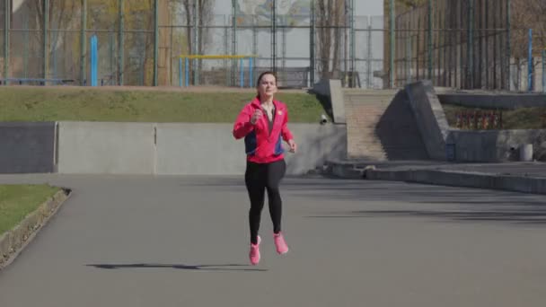 Mladá dívka dělat závod na stadionu - Záběry, video