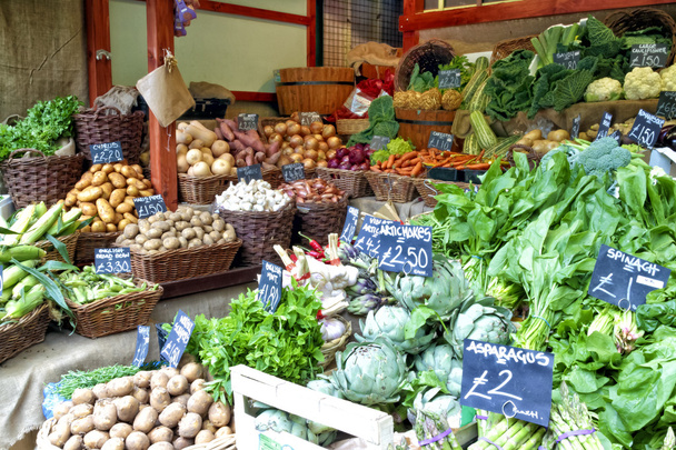 Разнообразие корней, зеленых овощей в корзинах с ценниками на рынке
. - Фото, изображение