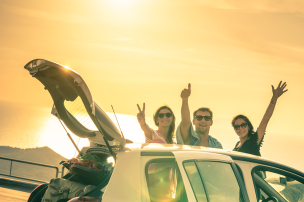 Найкращі друзі підбадьорюють подорож автомобілем на заході сонця - Група щасливих людей, що виходять на відпочинок - Концепція дружби під час подорожей з позитивними ностальгічними емоціями - М'який фокус через контраст підсвічування
 - Фото, зображення