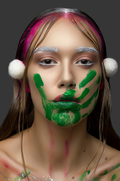Belle jeune femme avec un maquillage propre peau fraîche rose et empreinte à la main avec de la peinture verte
 - Photo, image