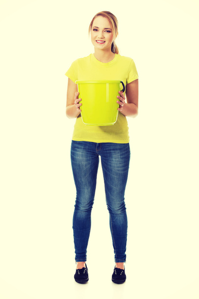 Young woman holding green bucket. - Foto, immagini