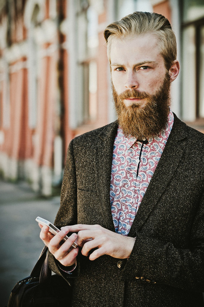 Young bearded man with mobile, outdoor - Photo, Image