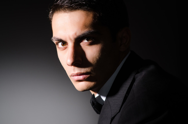 Young businessman in dark studio - Fotó, kép
