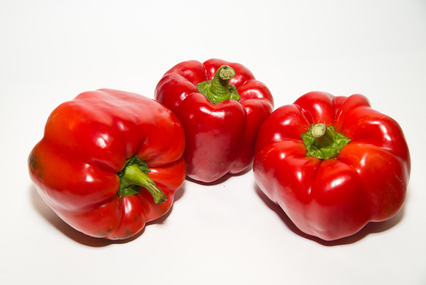 Tre peperoni rossi maturi su più bianco
 - Foto, immagini