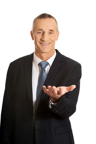 Businessman holding something on his palm - Foto, afbeelding
