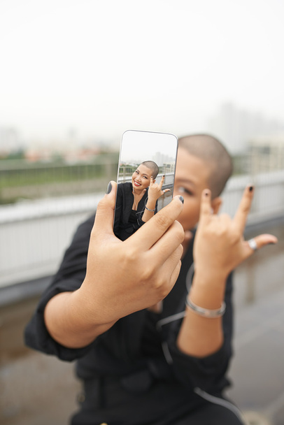 Mujer asiática mostrando gesto de roca
 - Foto, imagen