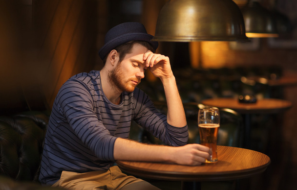 unhappy lonely man drinking beer at bar or pub - Photo, image