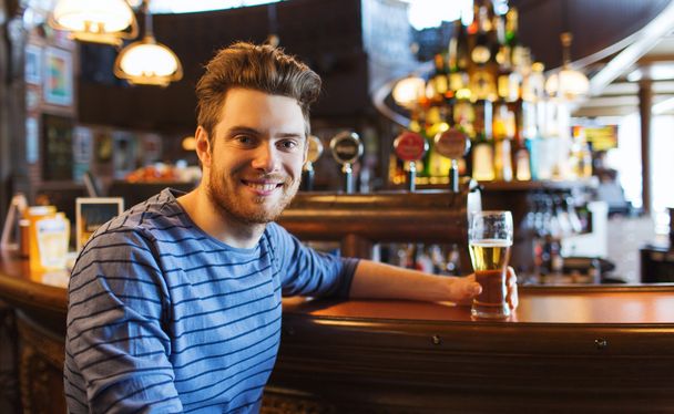 glücklicher Mann, der Bier in Bar oder Kneipe trinkt - Foto, Bild