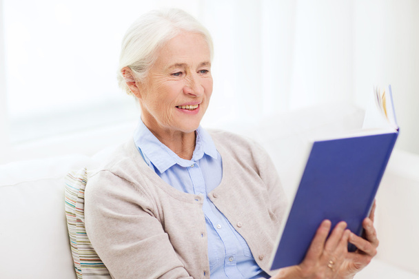 happy smiling senior woman reading book at home - Foto, imagen