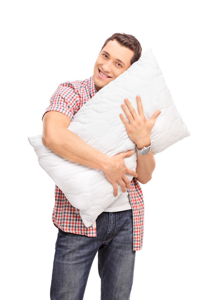 young man hugging a pillow - 写真・画像