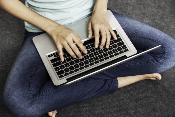 dizüstü bilgisayar kullanırken oturan genç kadın - Fotoğraf, Görsel
